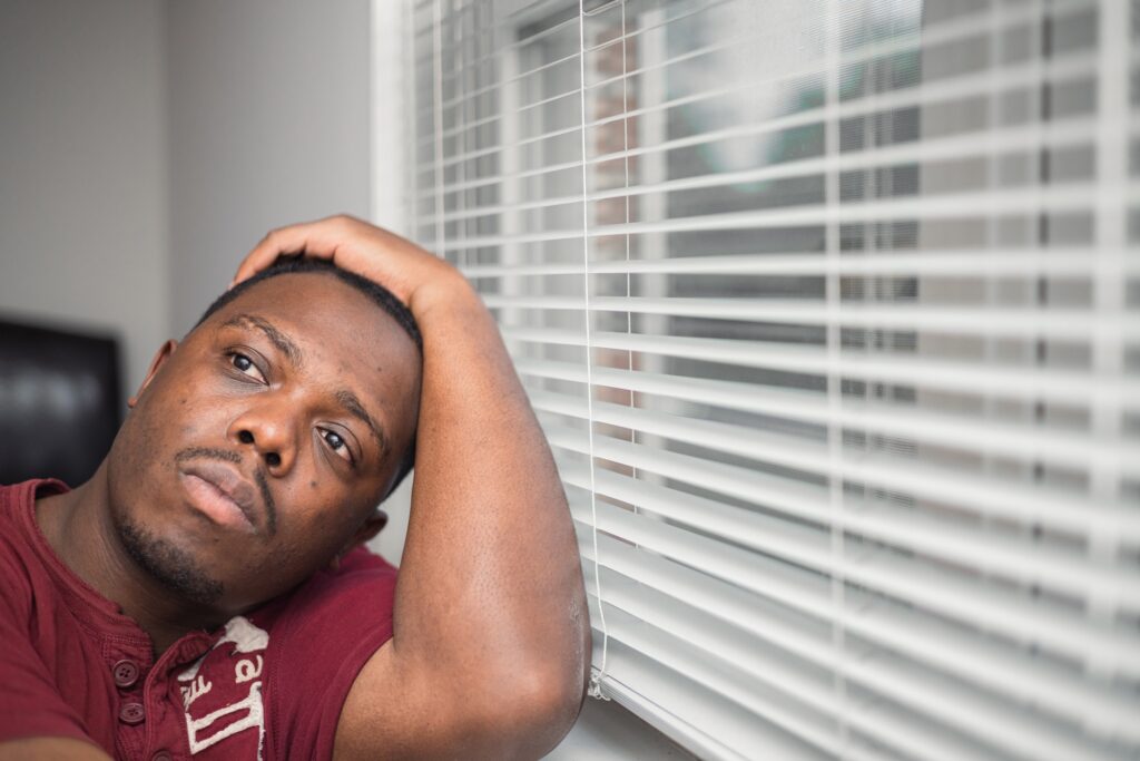 Mental health concept an African American or black man at home looking sad depressed with anxiety